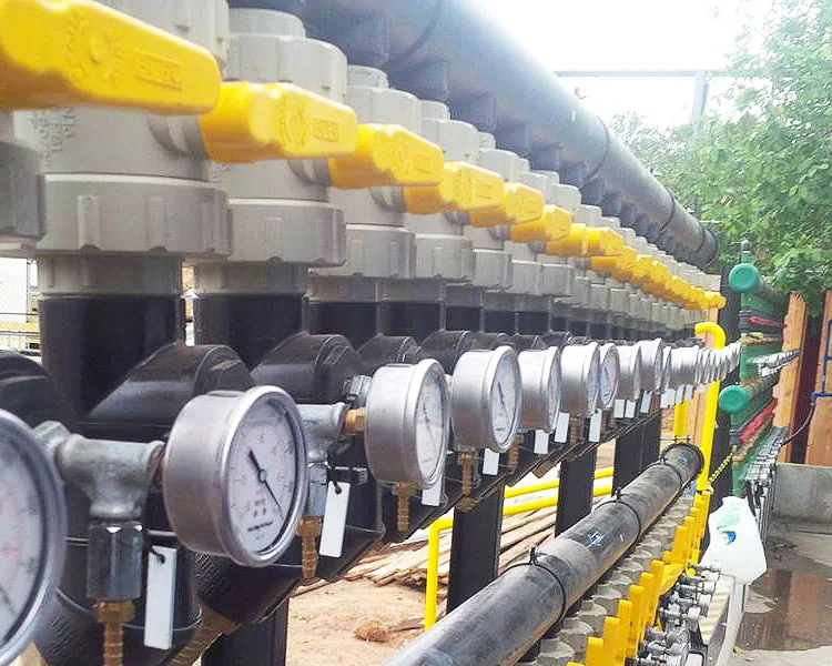 Linha externa de tubulação industrial com válvulas manuais e manômetros